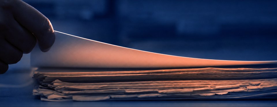 Vers geprint blad dat van een stapel vergeeld papier wordt gelicht