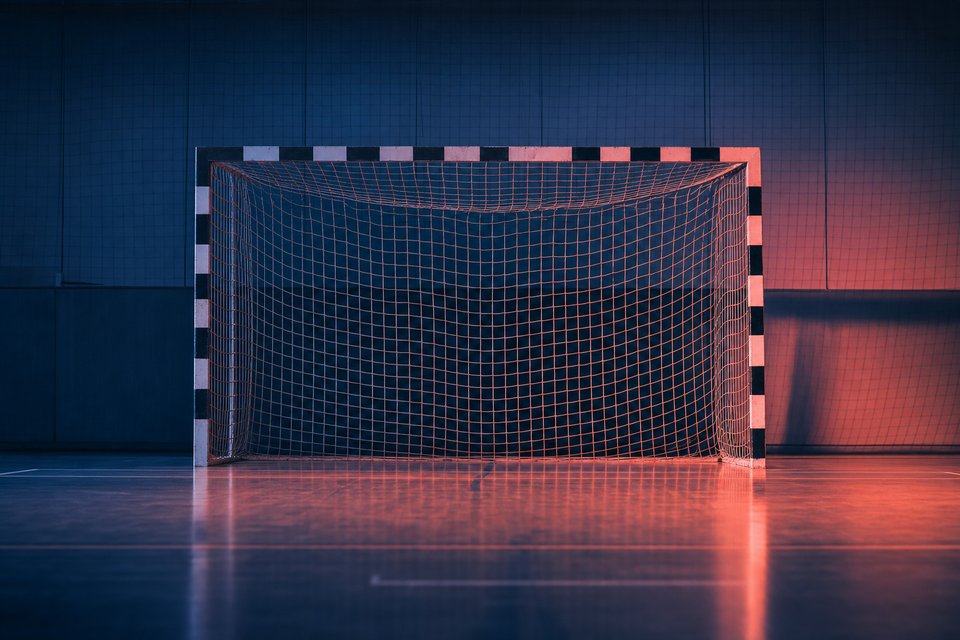 Handbaldoel en gespannen net in een sporthal onder zaallicht