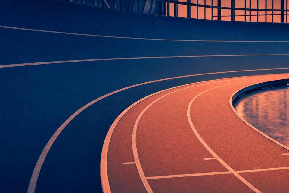 Schuine bocht van een lege indoor atletiekbaan van 200 meter