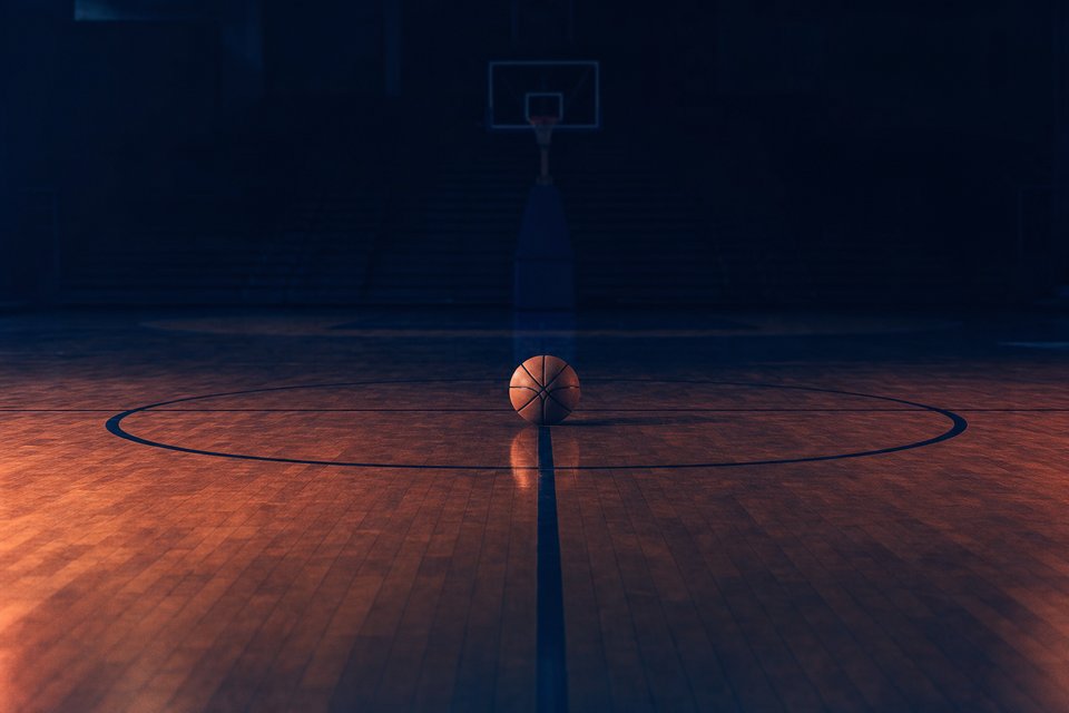 Basketbal op de middencirkel van een parketvloer in een onverlichte hal